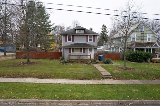 view of front of home with a front lawn and fence