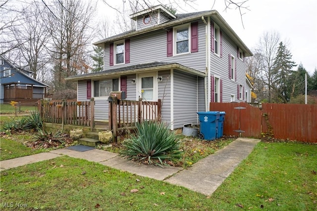 american foursquare style home with a front yard and fence