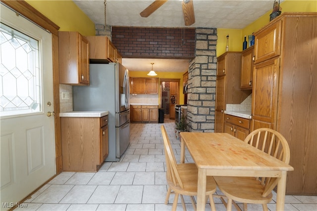 kitchen with backsplash, a healthy amount of sunlight, light tile patterned flooring, and pendant lighting