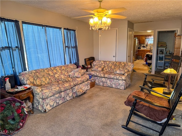 living room with ceiling fan, light carpet, and a textured ceiling