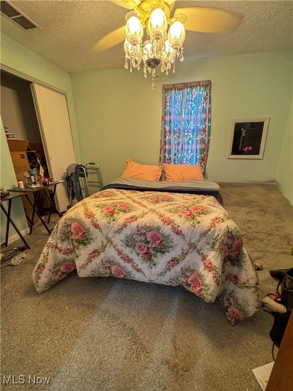 carpeted bedroom featuring ceiling fan, a closet, and a textured ceiling