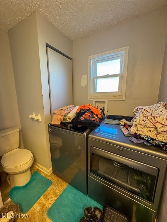 washroom with a textured ceiling and washing machine and clothes dryer