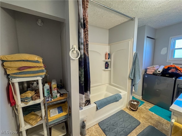 bathroom with shower / tub combo with curtain, a textured ceiling, and independent washer and dryer