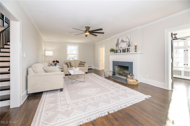 living room featuring dark hardwood / wood-style flooring, ceiling fan, ornamental molding, and radiator heating unit