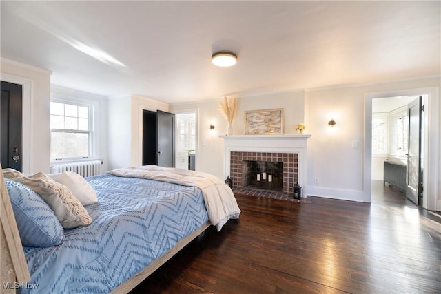 bedroom with radiator, a tile fireplace, crown molding, and dark hardwood / wood-style floors