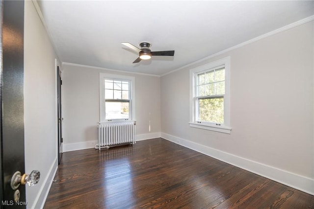 empty room featuring ornamental molding, dark wood-type flooring, radiator heating unit, and a healthy amount of sunlight