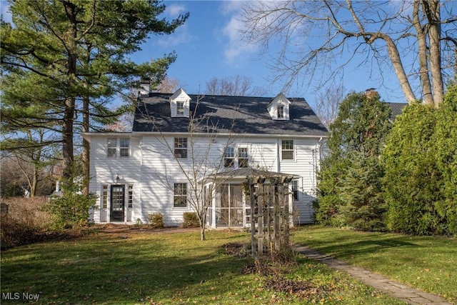 back of house with a lawn and a sunroom