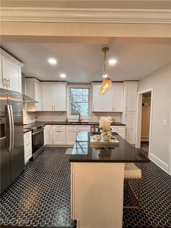 kitchen featuring hanging light fixtures, stainless steel appliances, a kitchen island, sink, and white cabinetry