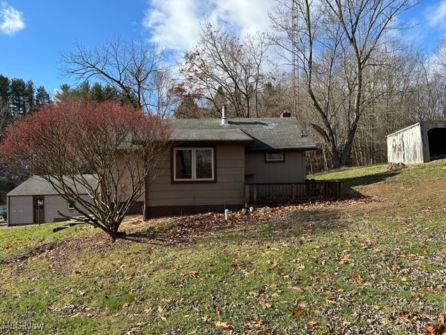 view of property exterior with a lawn and a shed