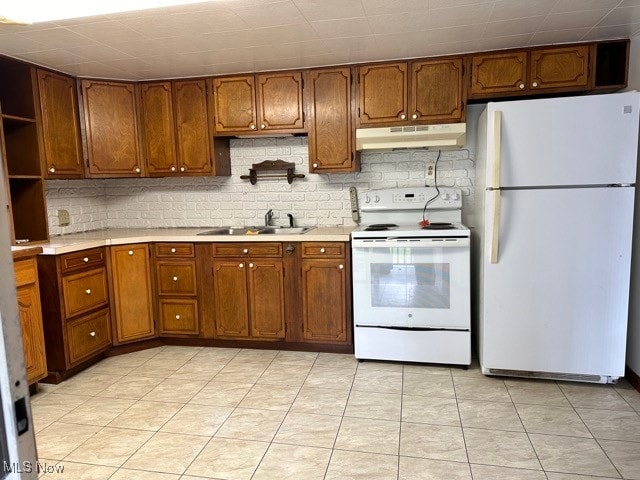 kitchen with backsplash, white appliances, sink, and light tile patterned floors