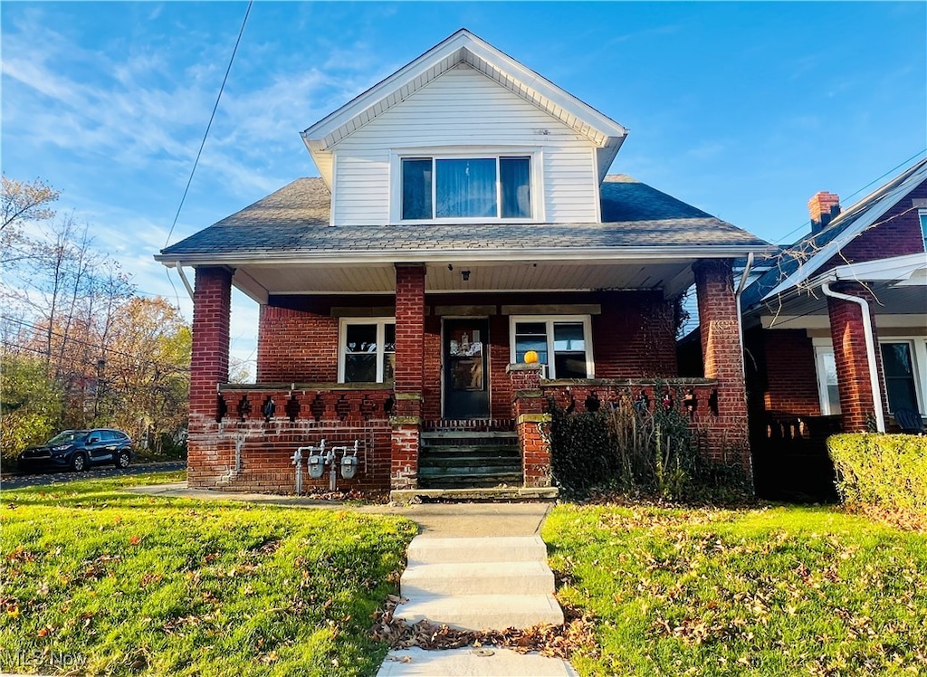 view of front of property with a porch and a front yard