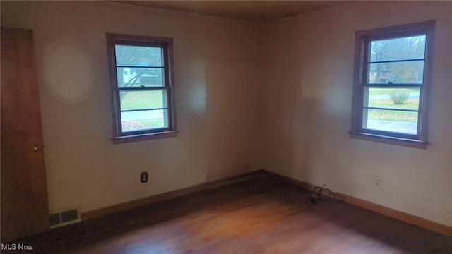 spare room with hardwood / wood-style floors and a healthy amount of sunlight