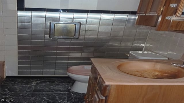 bathroom with vanity, tile walls, and toilet