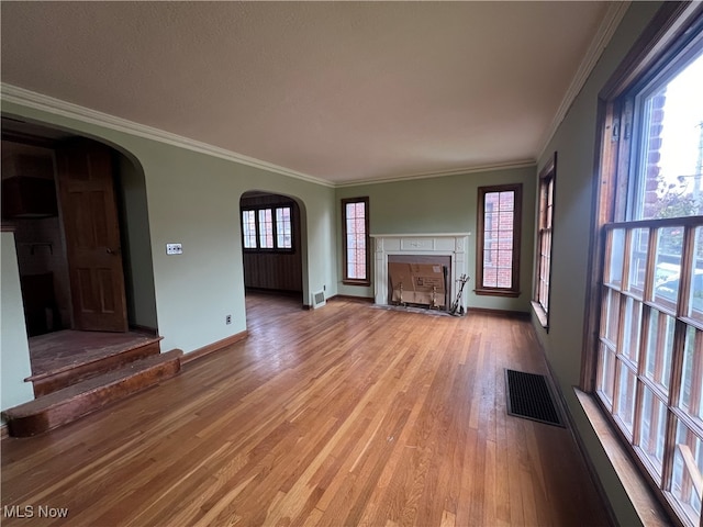 unfurnished living room with ornamental molding and light wood-type flooring