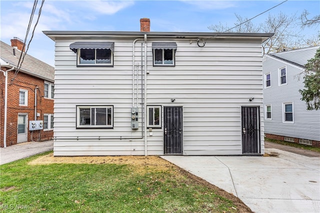 rear view of property featuring a lawn