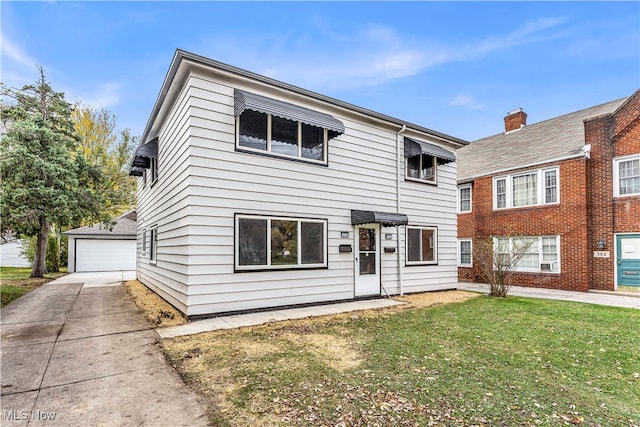 view of front of property featuring an outbuilding, a garage, and a front yard