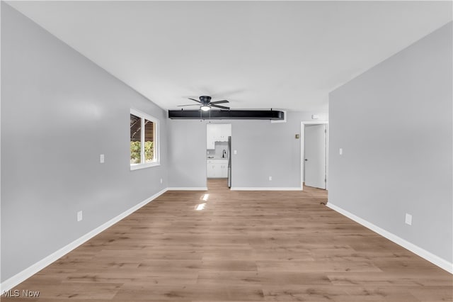 unfurnished living room featuring ceiling fan and light hardwood / wood-style flooring