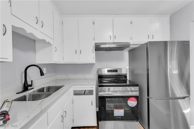 kitchen featuring light stone countertops, appliances with stainless steel finishes, white cabinetry, and sink