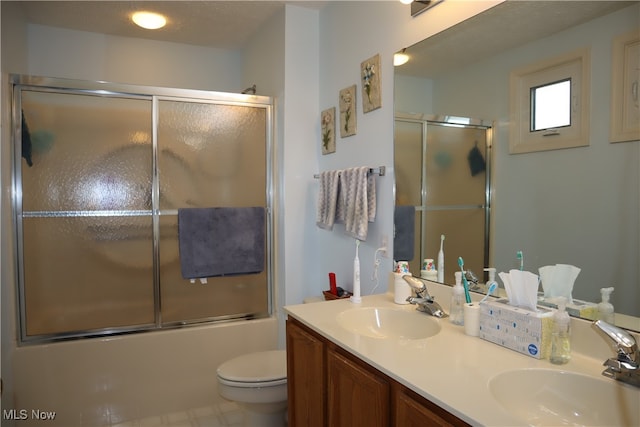 full bathroom with vanity, toilet, enclosed tub / shower combo, and a textured ceiling