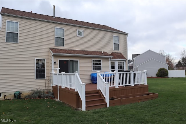 back of house featuring a lawn and a wooden deck