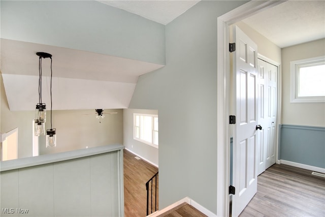 interior space with a healthy amount of sunlight, lofted ceiling, and light hardwood / wood-style flooring