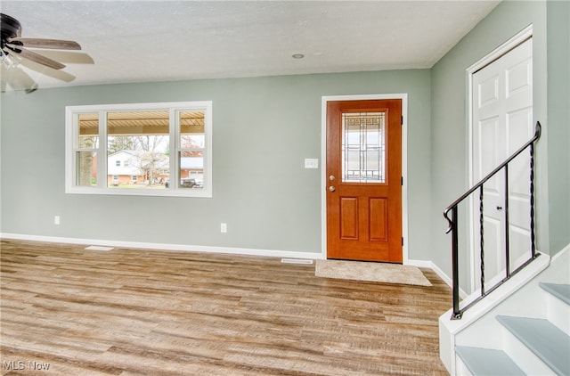 entryway with ceiling fan, light wood-type flooring, and a textured ceiling