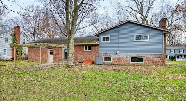 rear view of property with cooling unit, a patio area, and a lawn