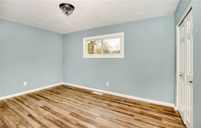 empty room featuring hardwood / wood-style floors and a textured ceiling