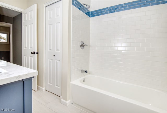 bathroom with tile patterned flooring, vanity, and tiled shower / bath