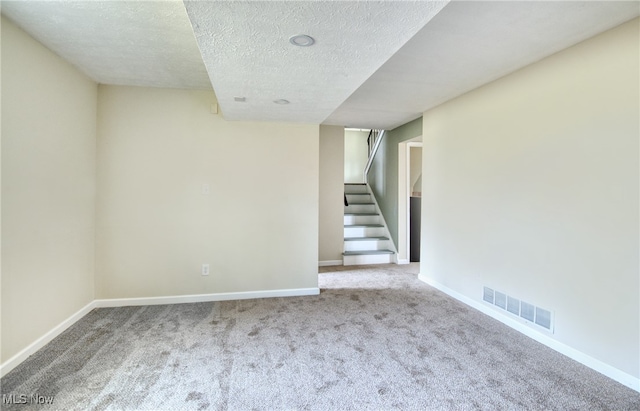 unfurnished room with carpet flooring and a textured ceiling