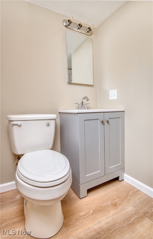 bathroom with vanity, toilet, and wood-type flooring