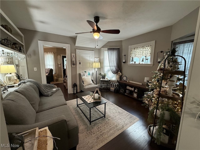 living room featuring ceiling fan and dark hardwood / wood-style flooring