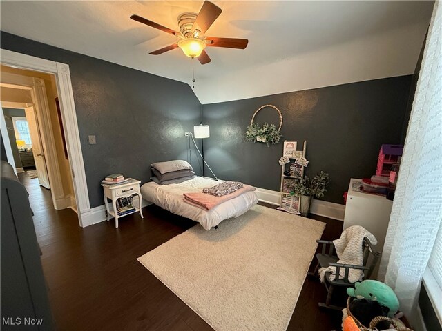 bedroom featuring ceiling fan, dark hardwood / wood-style floors, and vaulted ceiling