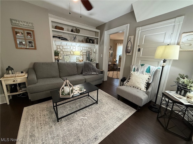 living room with ceiling fan, dark hardwood / wood-style flooring, and built in features