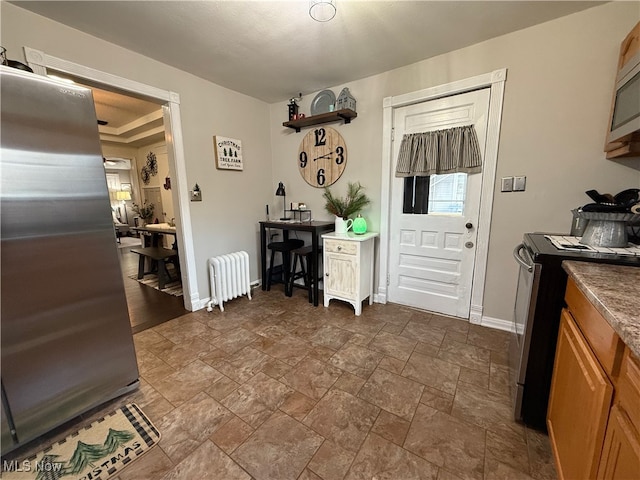 kitchen featuring radiator heating unit and appliances with stainless steel finishes