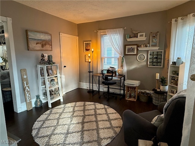 living area featuring a textured ceiling and dark hardwood / wood-style flooring