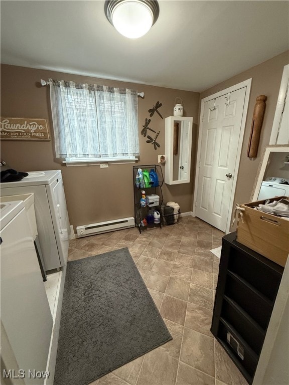 clothes washing area with baseboard heating, washing machine and clothes dryer, and cabinets