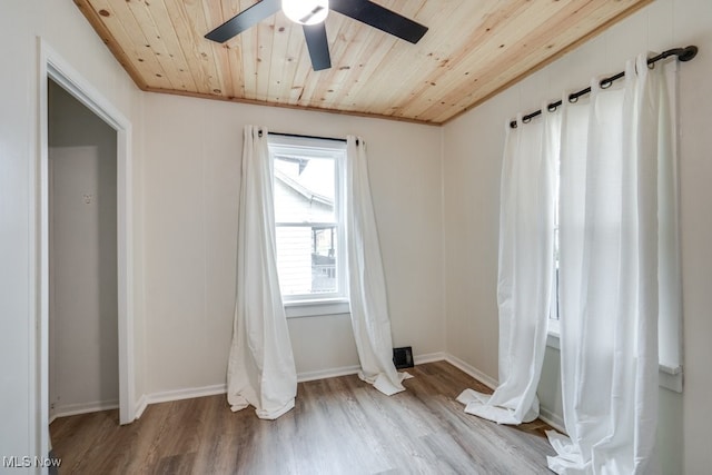 empty room with ceiling fan, light hardwood / wood-style floors, wood ceiling, and crown molding