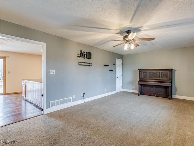 empty room with wood-type flooring, a textured ceiling, and ceiling fan