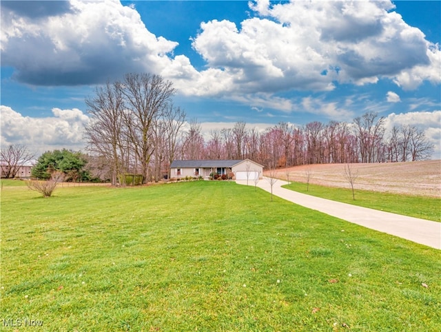 view of yard featuring a garage and a rural view