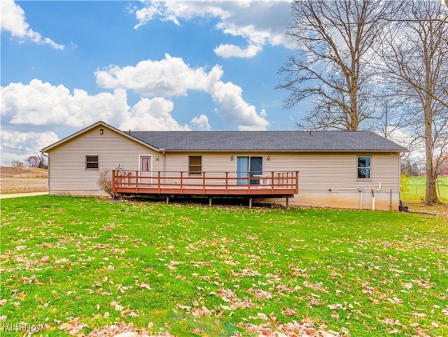 rear view of house featuring a lawn and a wooden deck