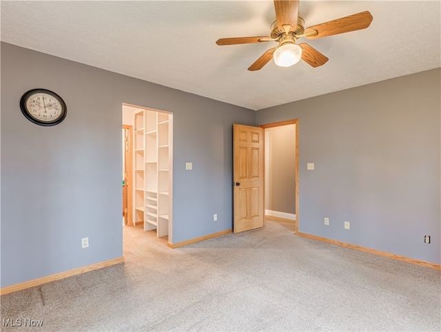 carpeted empty room with a textured ceiling and ceiling fan