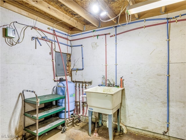 basement with electric panel and sink