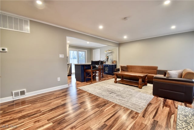 living room with hardwood / wood-style flooring and crown molding