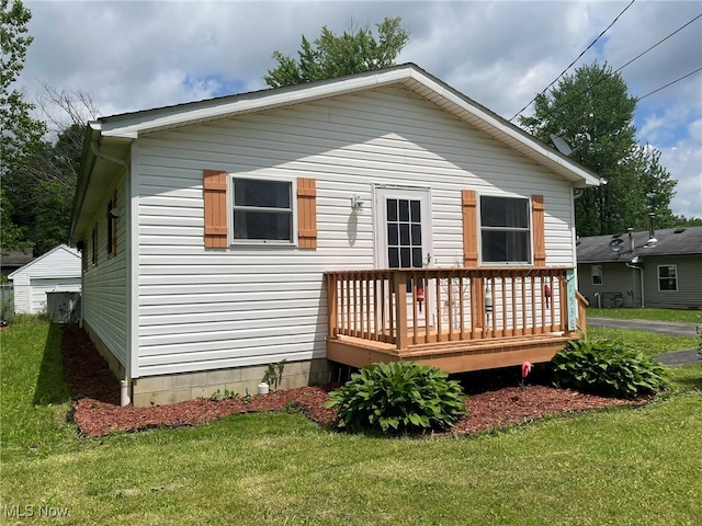 rear view of property with a yard and a wooden deck