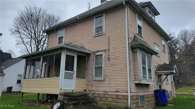 rear view of property featuring a sunroom