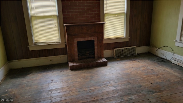 unfurnished living room featuring dark hardwood / wood-style flooring, a fireplace, and radiator