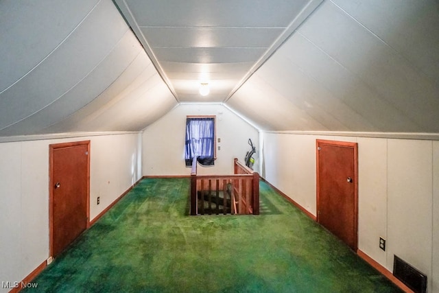 bonus room featuring dark carpet and vaulted ceiling