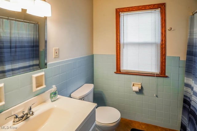 bathroom with a shower with shower curtain, vanity, toilet, and tile walls