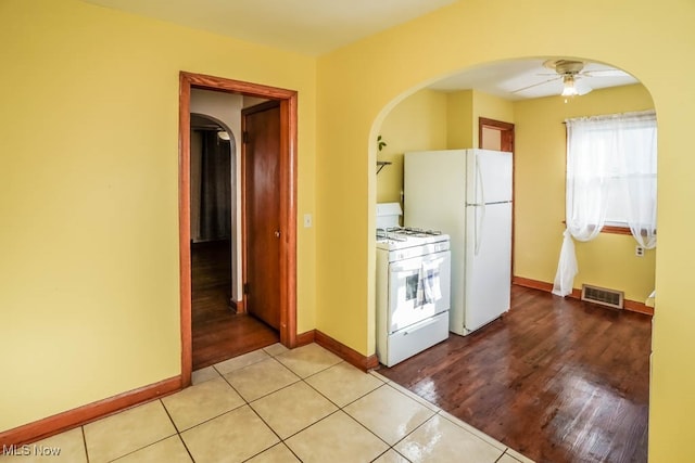 kitchen featuring ceiling fan, light hardwood / wood-style flooring, and white appliances